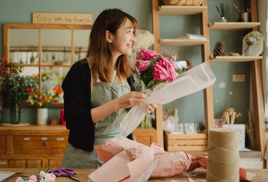 A florist arranging fresh flowers on the workbench inside the Bloom & Stem shop