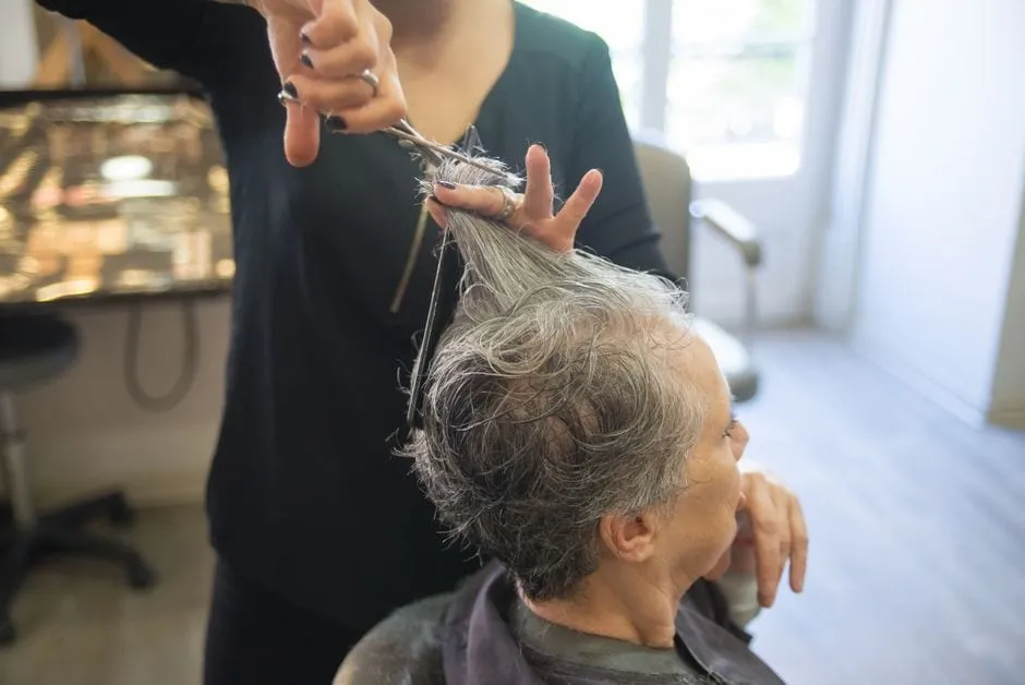 A Lumière stylist cutting a client's hair with precision scissors