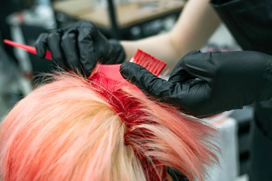 Vivid hair colour being applied by hand during a colour service