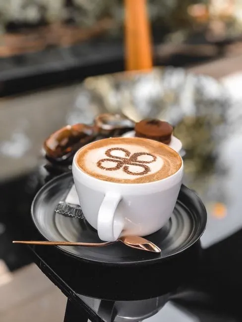 A flat white with delicate latte art in a ceramic cup on the café counter