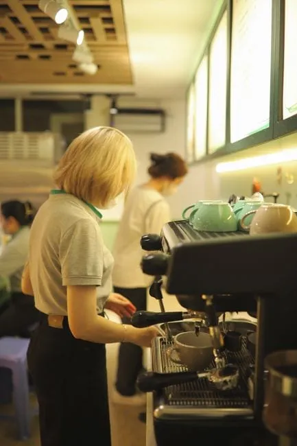 A friendly barista serving a customer at The Daily Grind's café counter